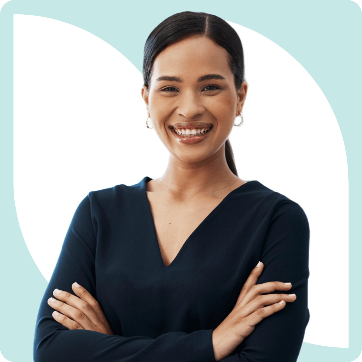A person with long hair smiles, wearing a dark blouse and hoop earrings, standing with arms crossed against a light blue and white background.